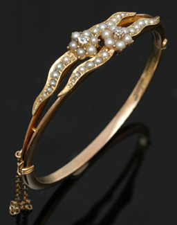 Appraisal: An Edwardian diamond and seed pearl bangle The hinged bangle