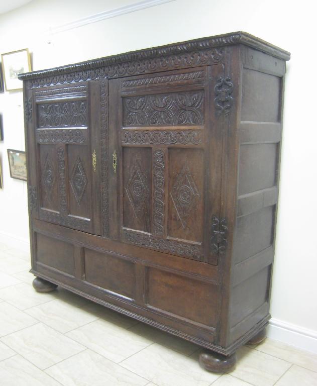 Appraisal: A th Century oak Wardrobe with carved frieze above pair