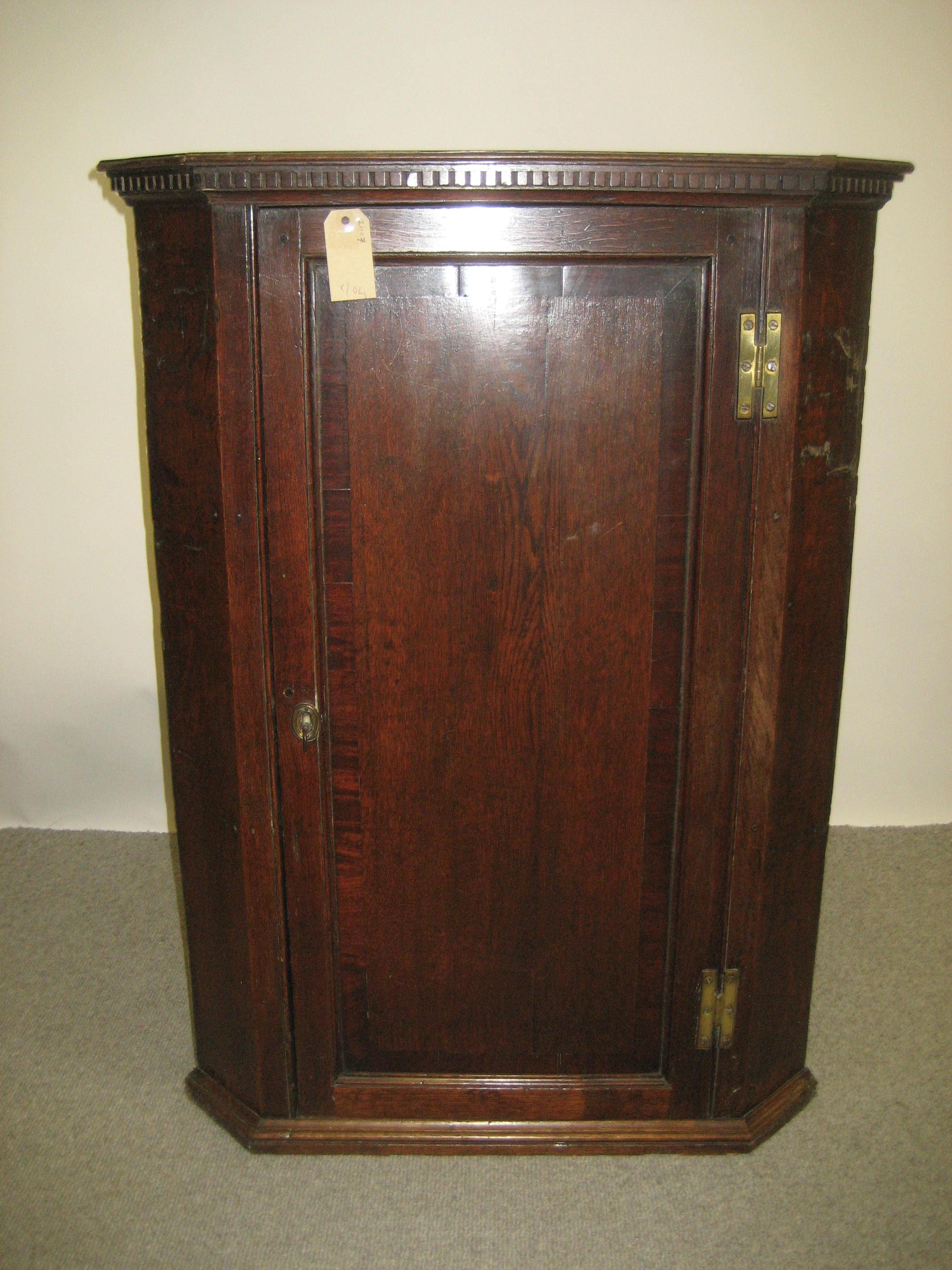 Appraisal: AN OAK CORNER CUPBOARD early th century the dentil moulded