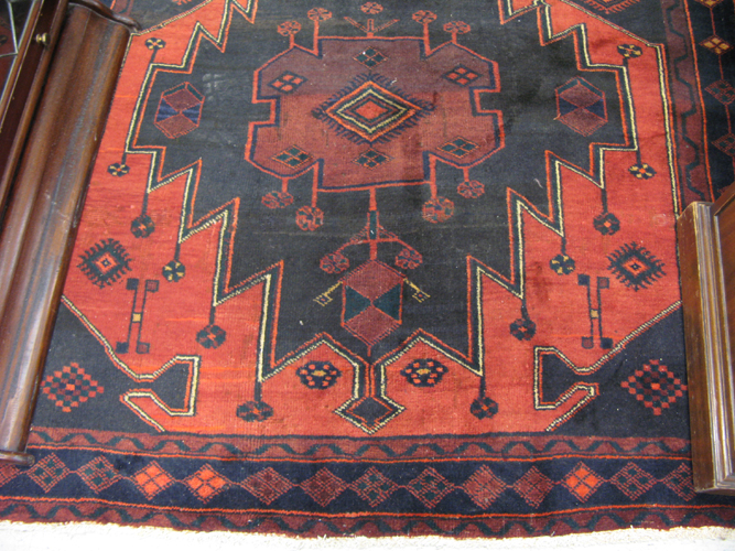 Appraisal: PERSIAN TRIBAL CARPET featuring three extra large geometric medallions on