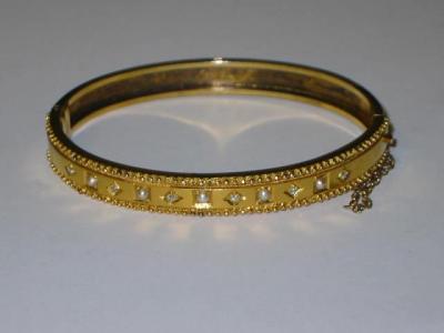 Appraisal: A PEARL AND DIAMOND GOLD BANGLE of hinged form the