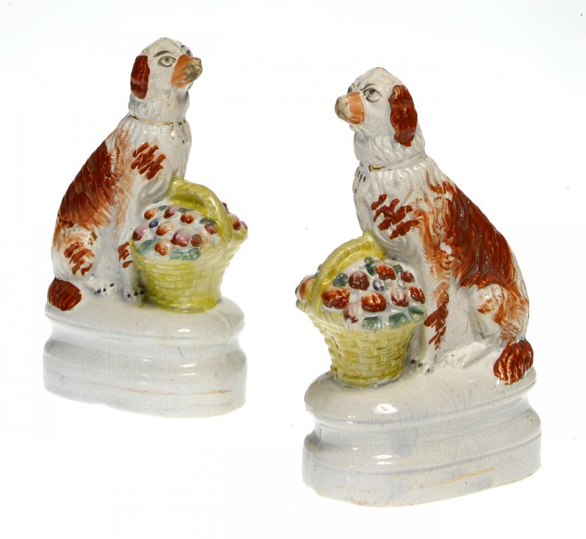 Appraisal: A PAIR OF STAFFORDSHIRE MODELS OF SPANIELS WITH BASKETS sponged