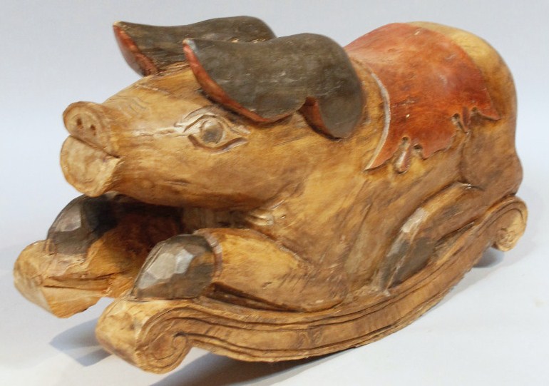 Appraisal: A thC carved rocking pig with partially painted saddle highlighted