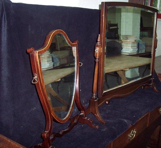 Appraisal: A mahogany swing framed mirror the shield shaped glass on