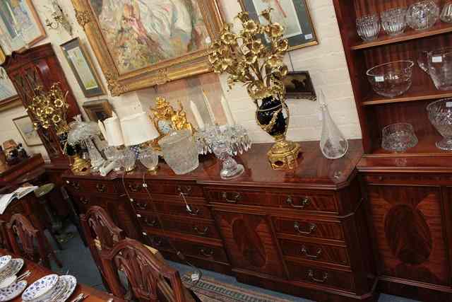 Appraisal: A BREAKFRONT MAHOGANY AND WALNUT CROSS BANDED SIDEBOARD the central