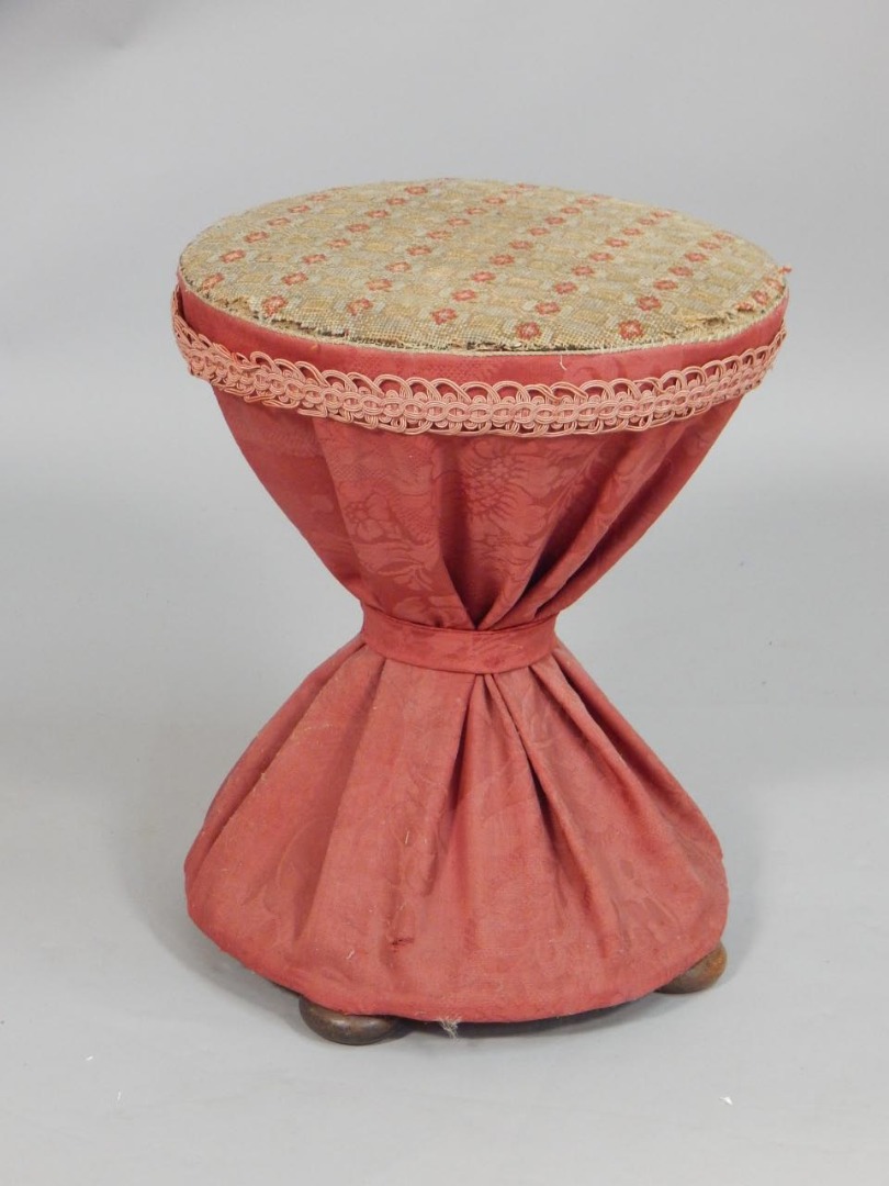 Appraisal: A Victorian hour glass shaped stool with a woolwork padded