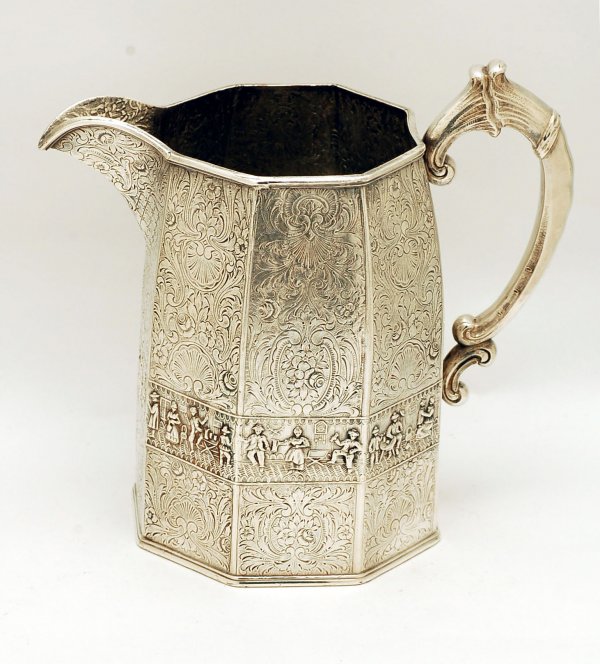 Appraisal: Silverplated water pitcher paneled sides decorated with family scenes and