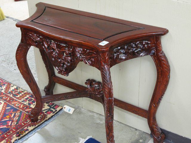 Appraisal: CARVED MAHOGANY CONSOLE TABLE having a shaped panel top on