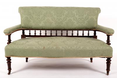 Appraisal: An upholstered settee with spindle turned supports and splay feet