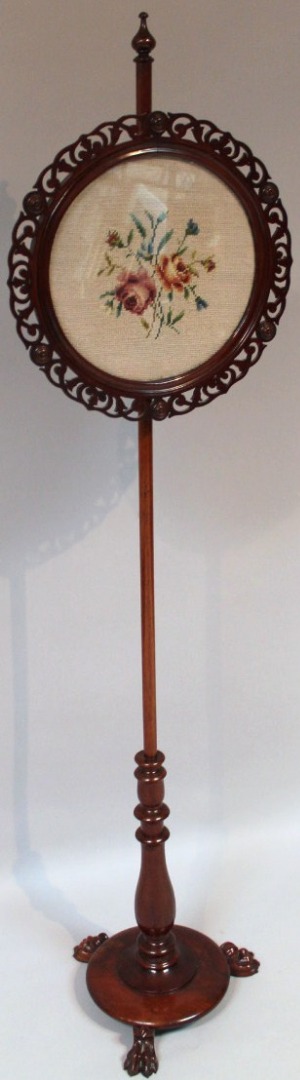 Appraisal: A Victorian mahogany pole screen the cylindrical stem surmounted by