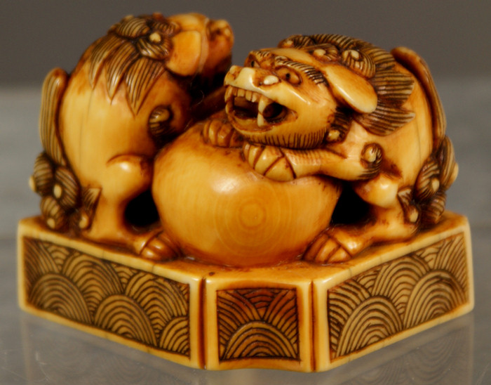 Appraisal: Netsuke Japanese ivory carving of a shishi playing with a