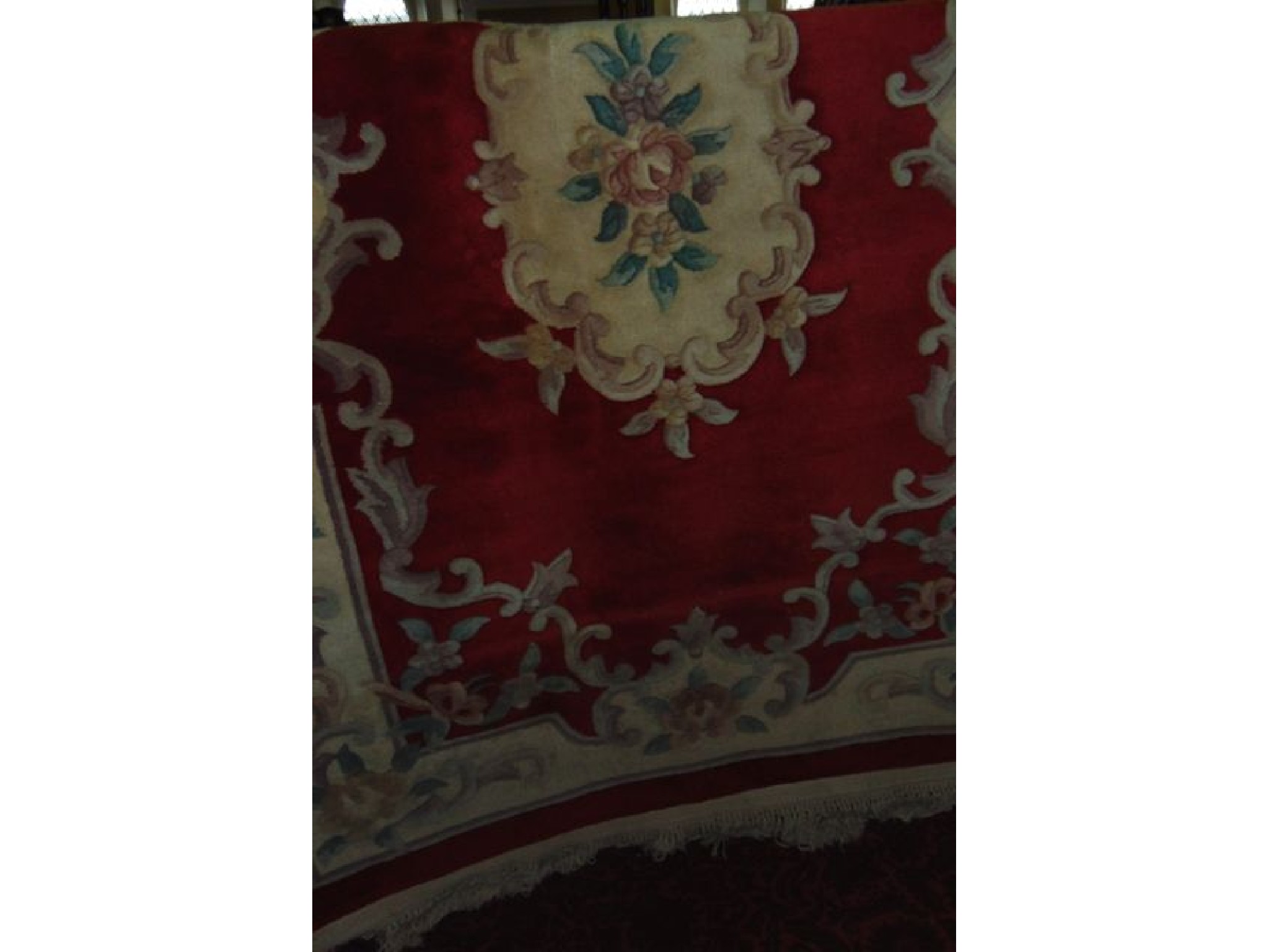 Appraisal: A Chinese red ground wool carpet with cream coloured borders