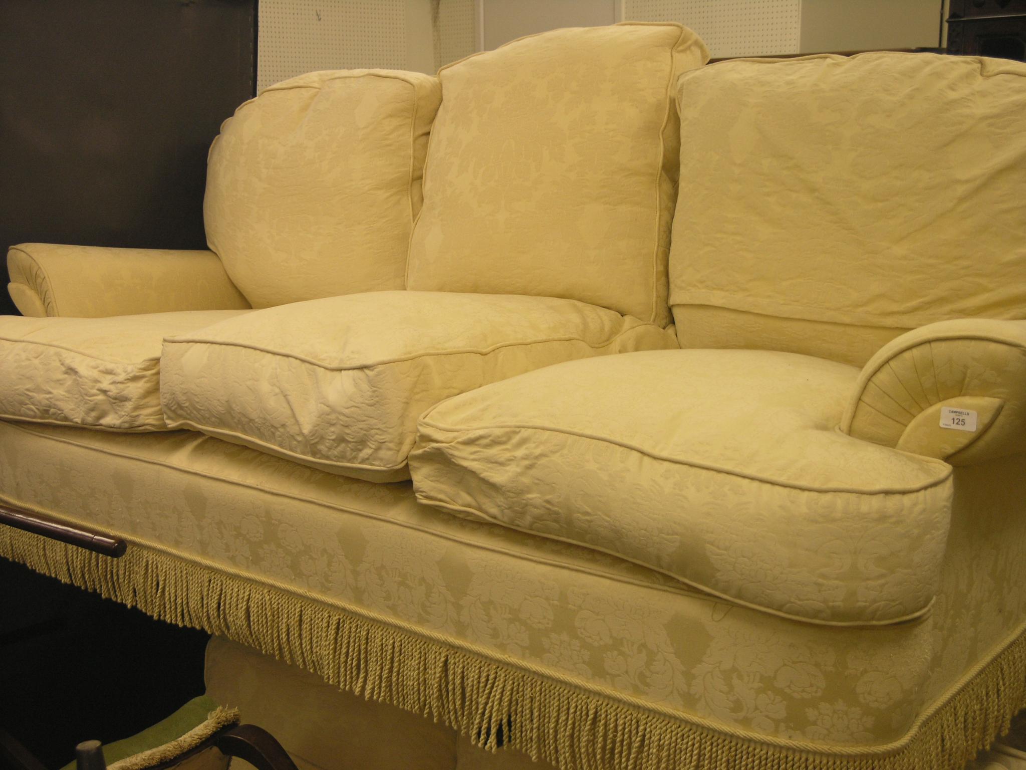 Appraisal: A three-seater settee upholstered in a gold and cream brocade