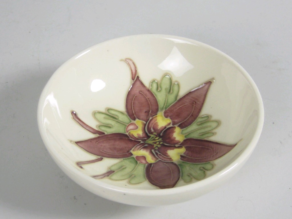 Appraisal: A Moorcroft small shallow Bowl Columbine design on a cream