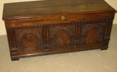 Appraisal: A CARVED OAK PANELLED COFFER with moulded edged hinged lid