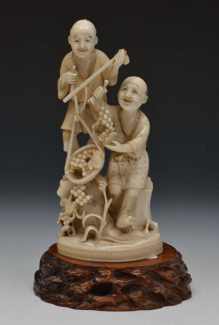 Appraisal: A JAPANESE IVORY OKIMONO two farmers gathering grapes one standing