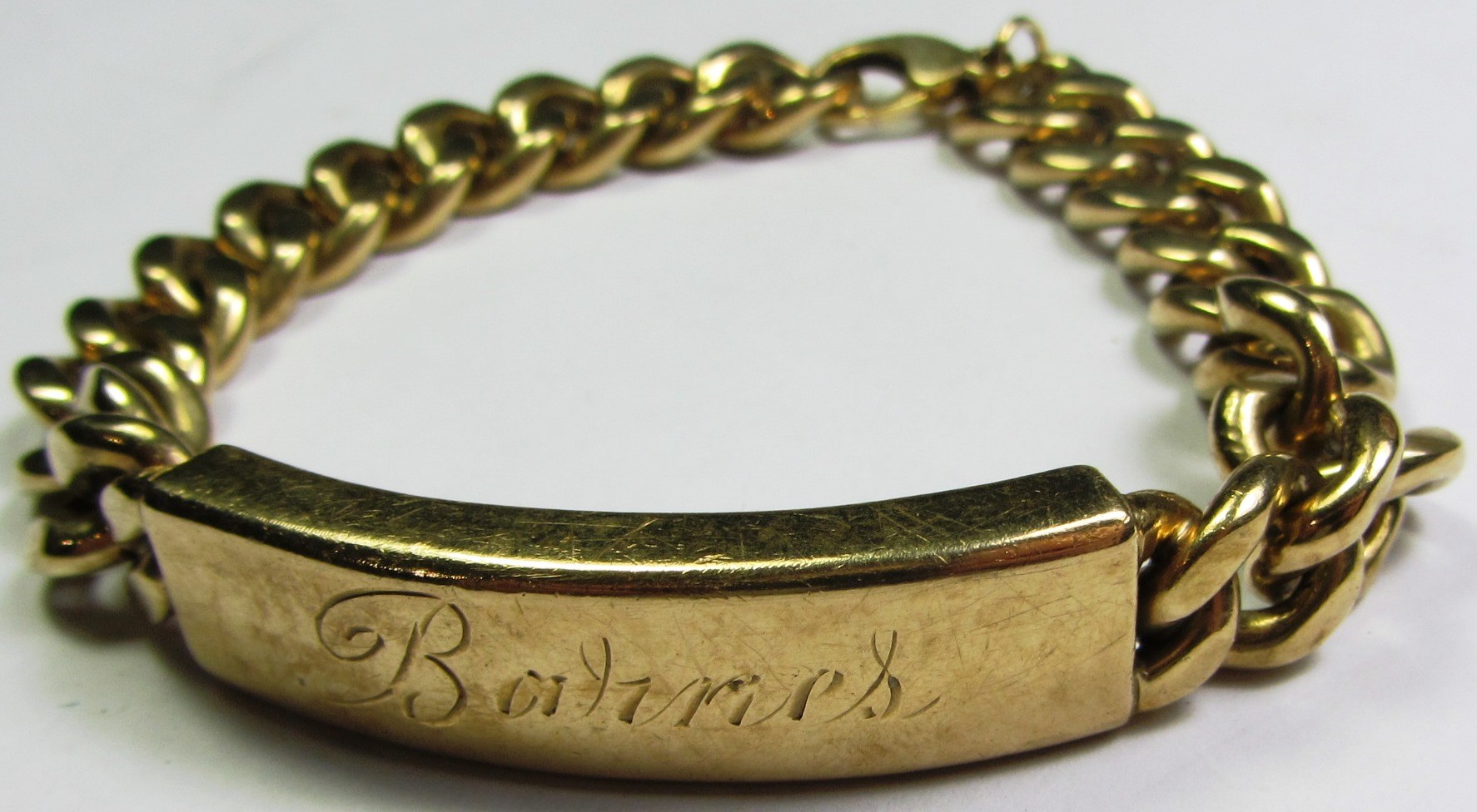 Appraisal: A ct gold faceted curb link identity bracelet detailed Barnes