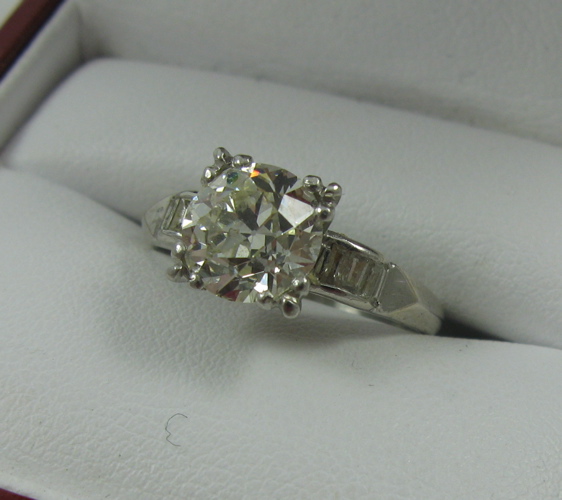 Appraisal: ESTATE DIAMOND AND PLATINUM RING centering a round-cut diamond with