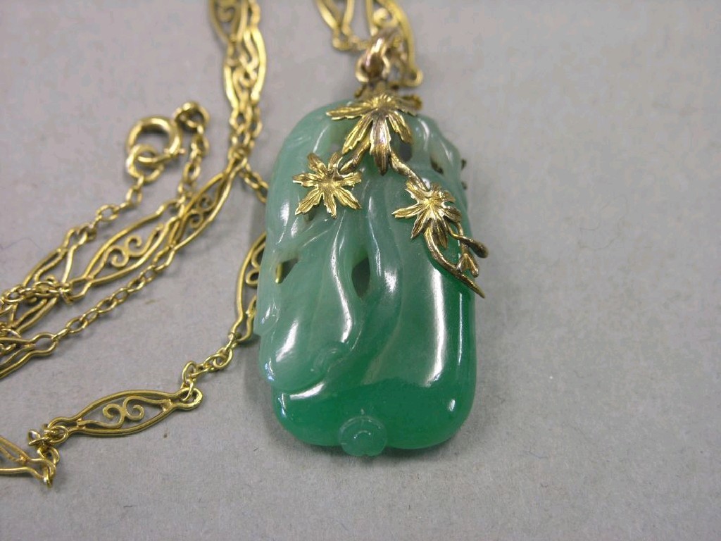 Appraisal: A carved jade pendant on pierced gold chain hallmark indistinct