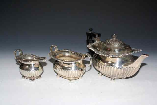 Appraisal: AN EDWARDIAN SILVER TEAPOT oval shaped with fluted lower body