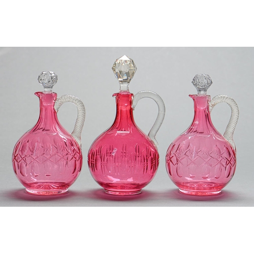 Appraisal: One and a pair of Victorian cranberry glass jugs with