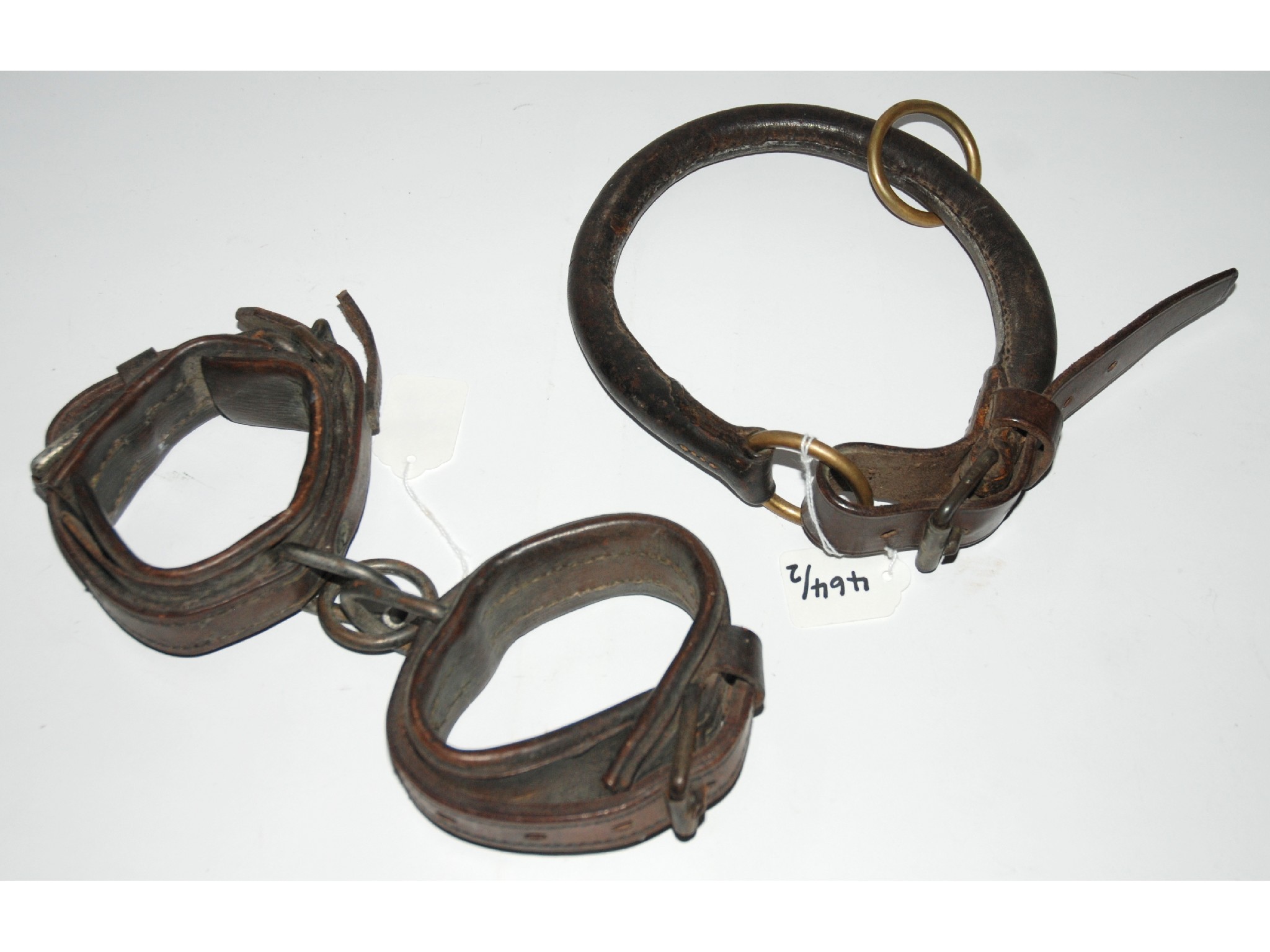 Appraisal: A pair of early leather shackles and leather restraint