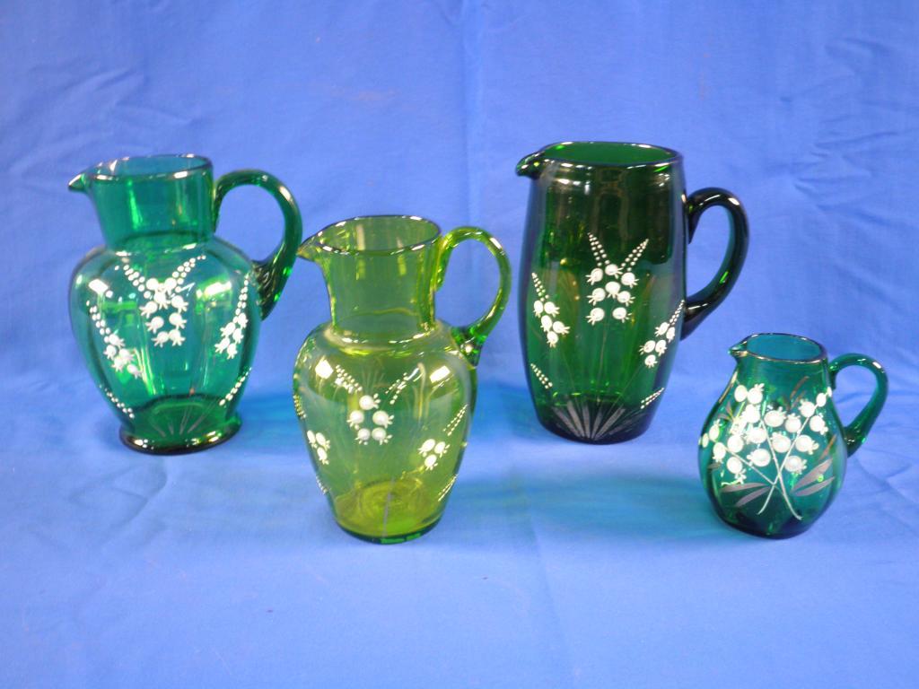 Appraisal: Four Victorian green glass jugs each decorated in white enamels