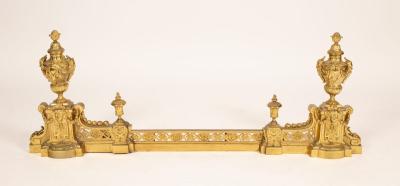 Appraisal: A polished brass adjustable fire curb surmounted by decorative urns