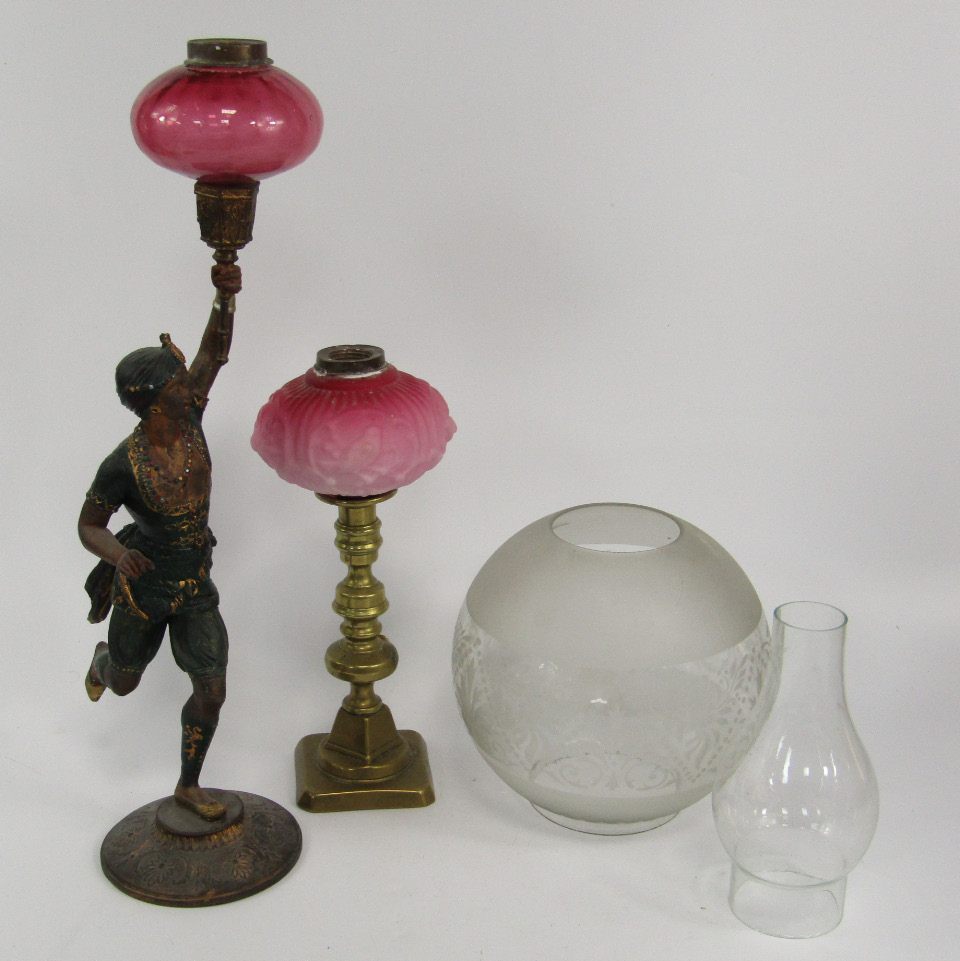 Appraisal: A cast metal oil lamp base modelled as an Indian