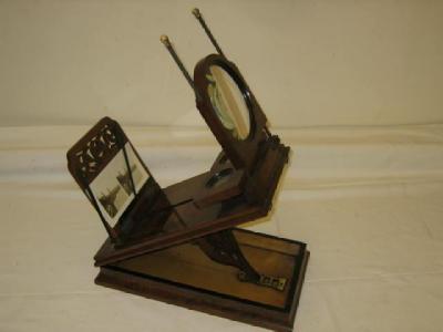 Appraisal: A PARLOUR GRAPHOSCOPE in walnut veneer case with adjustable pierced