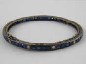 Appraisal: A white metal tests silver sapphire and diamond bangle approx