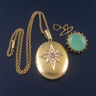 Appraisal: A Victorian gold oval locket pendant mounted with a seed