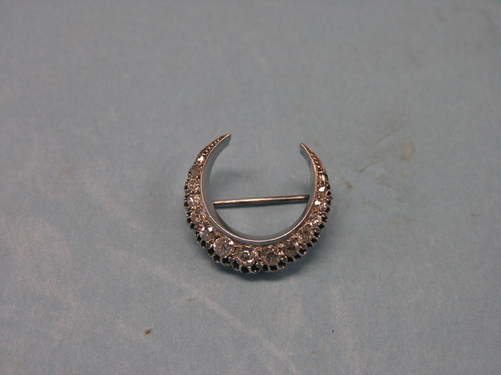 Appraisal: A diamond crescent brooch fourteen graduated diamonds white metal setting