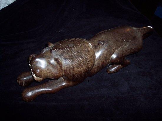 Appraisal: A carved hardwood figure of a crouching lion cm long