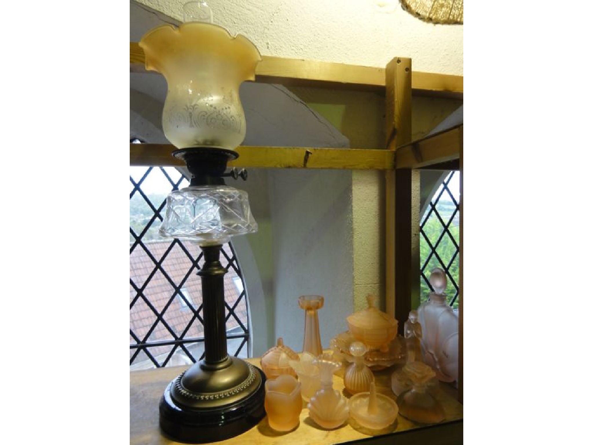 Appraisal: An oil lamp raised on a brass fluted column supporting