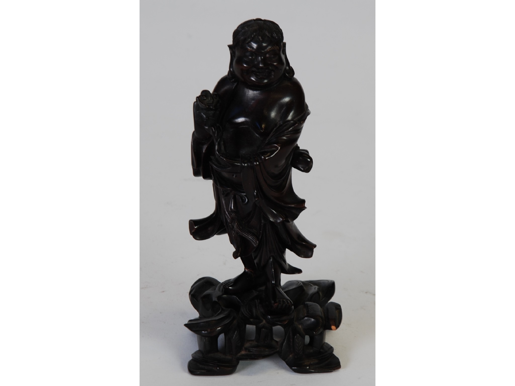 Appraisal: AN ORIENTAL CARVED DARK WOOD FIGURE OF HOTEI modelled standing