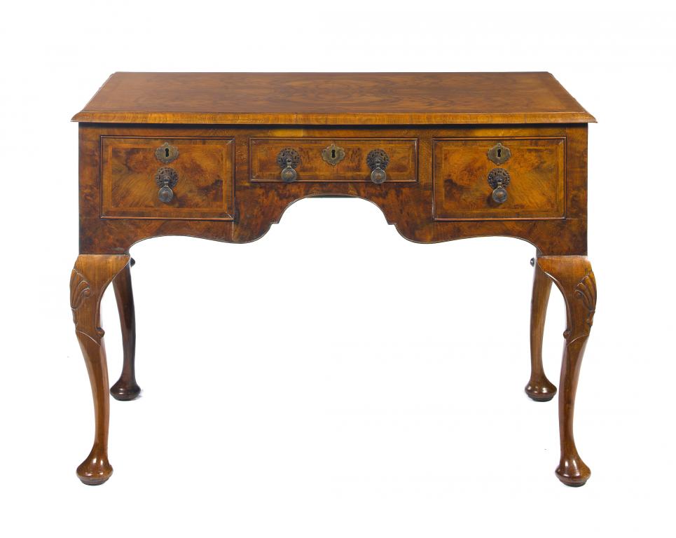 Appraisal: A WALNUT AND FEATHERBANDED LOWBOY with quarter veneered top and