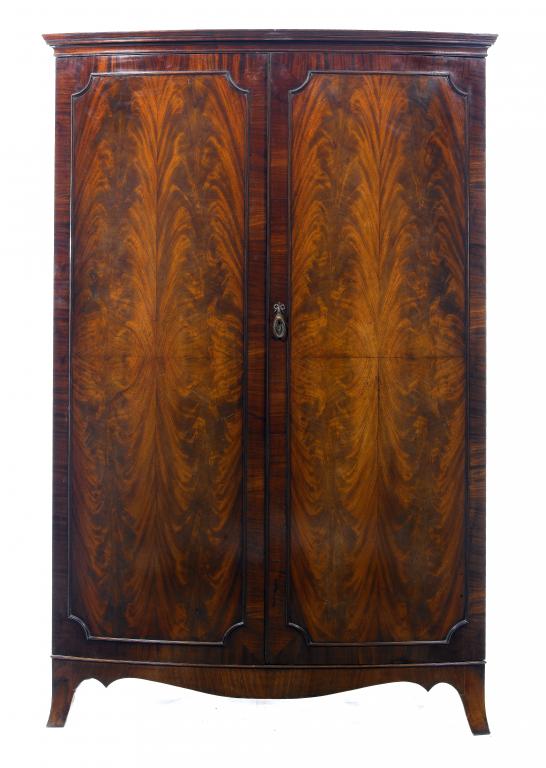 Appraisal: A MAHOGANY BOW FRONTED WARDROBE enclosed by a pair of