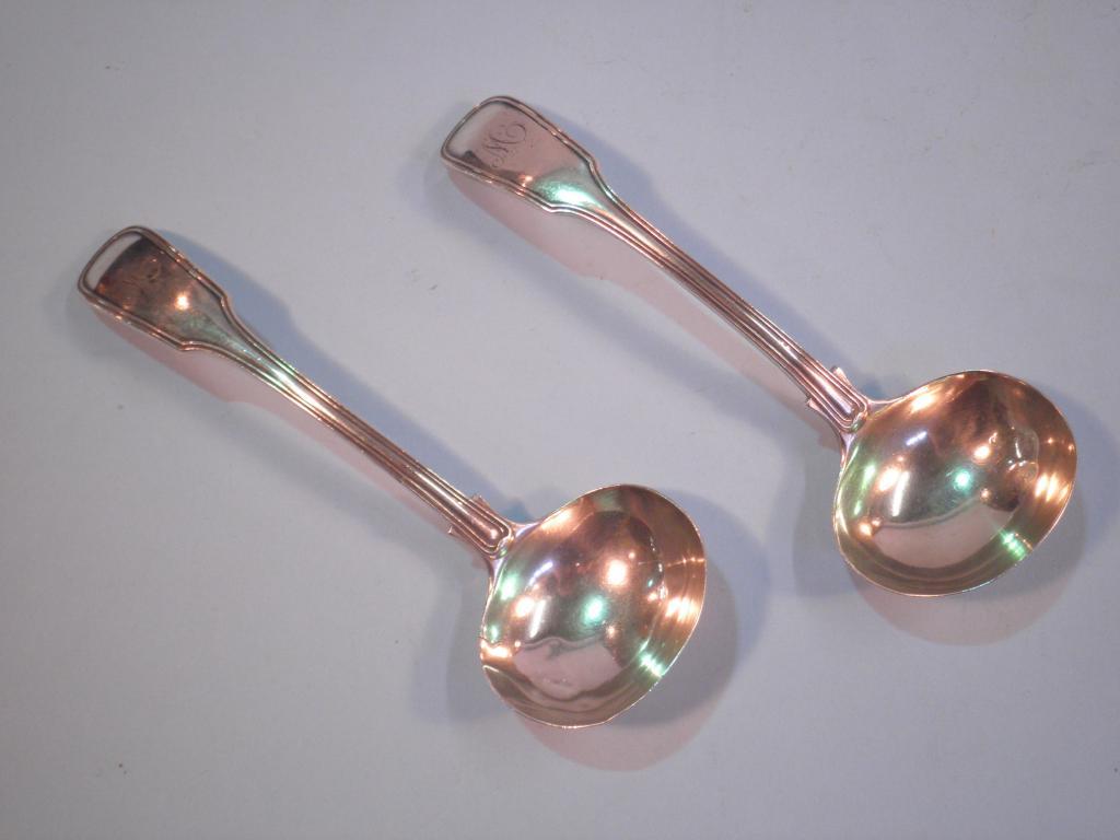 Appraisal: A pair of silver fiddle and thread pattern sauce ladles