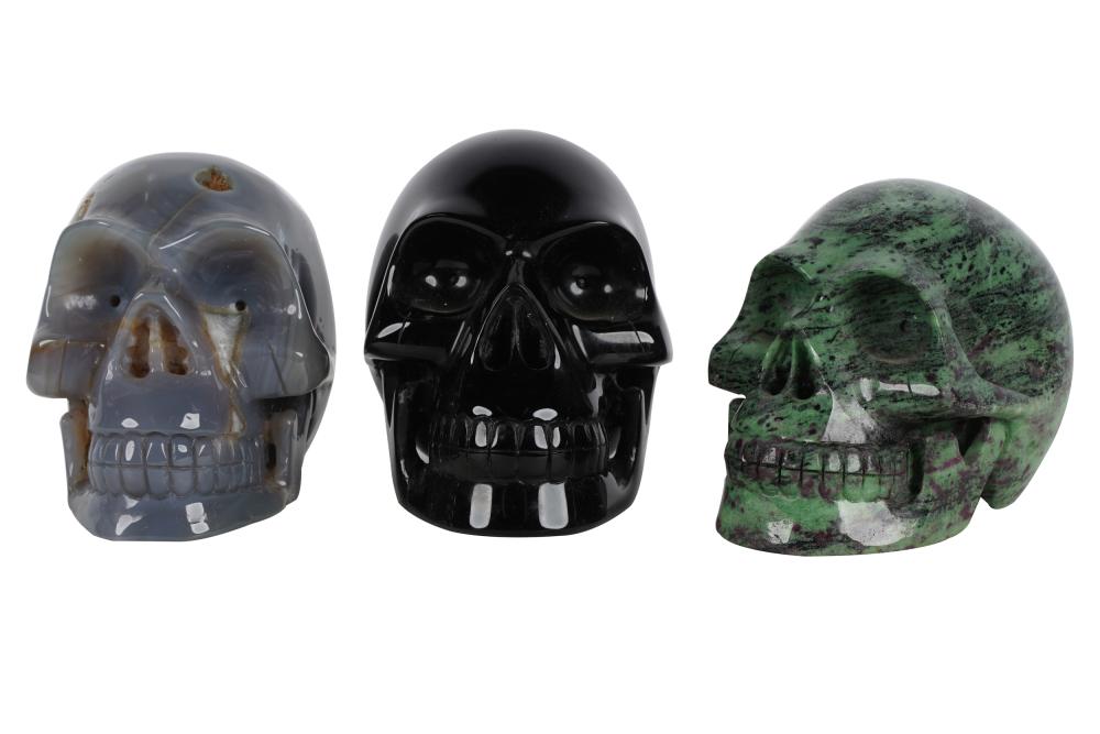 Appraisal: THREE CARVED STONE SKULLScomprising one black one green and one