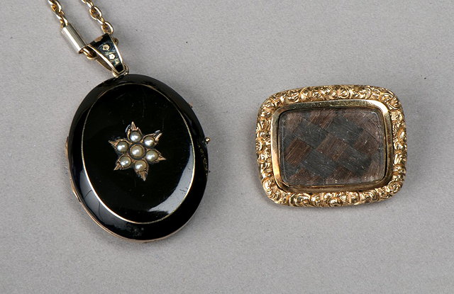 Appraisal: A VICTORIAN ENAMEL PEARL AND GILT METAL OVAL MOURNING LOCKET