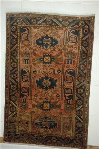 Appraisal: A HERIZ STYLE RUST GROUND CARPET with traditional geometric decoration