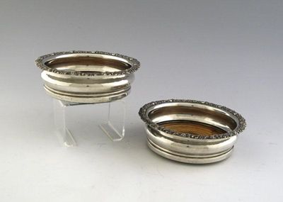 Appraisal: A pair of Old Sheffield plated wine coasters with foliate