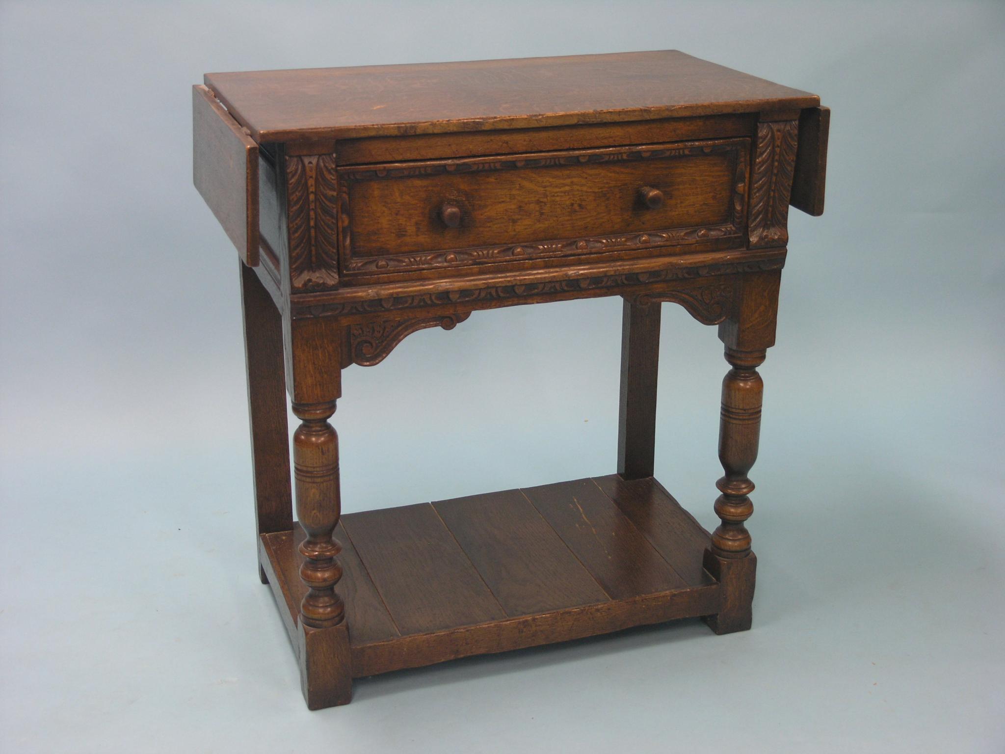 Appraisal: A solid dark oak drop-leaf hall table with single frieze