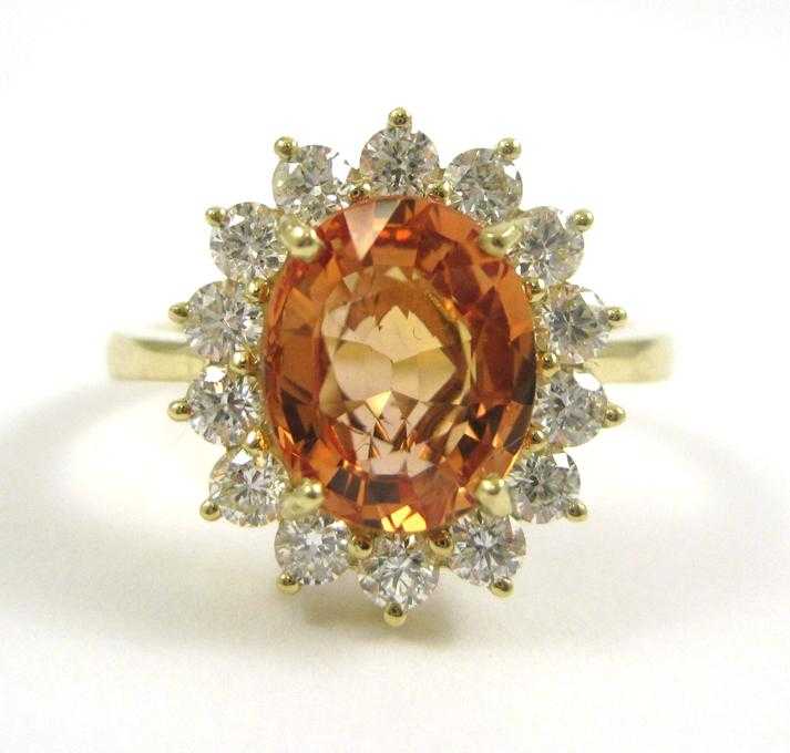 Appraisal: ORANGE SAPPHIRE AND FOURTEEN KARAT GOLD RING with round brilliant-cut