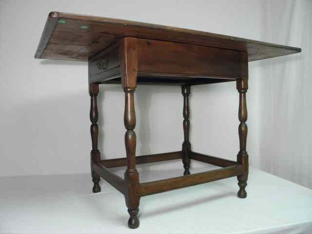 Appraisal: A one-drawer wide worktable with a Mahogany finish carved spindle