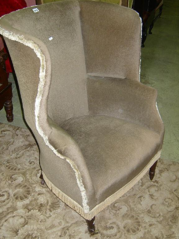 Appraisal: An th century enclosed wing chair with scrolled arms and