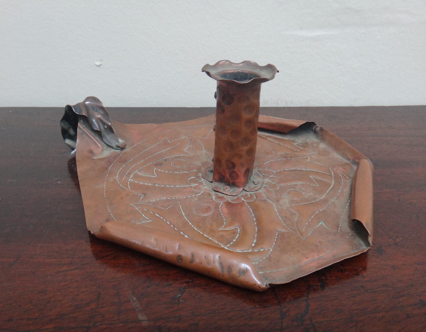 Appraisal: A Newlyn copper chamber stick of septagonal form embossed with