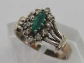 Appraisal: An emerald and diamond cluster ring the central navette cut