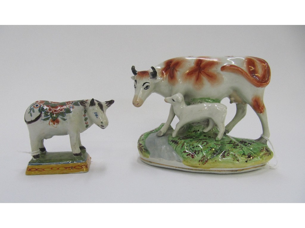 Appraisal: Tin glazed figure of a cow and a Staffordshire figure